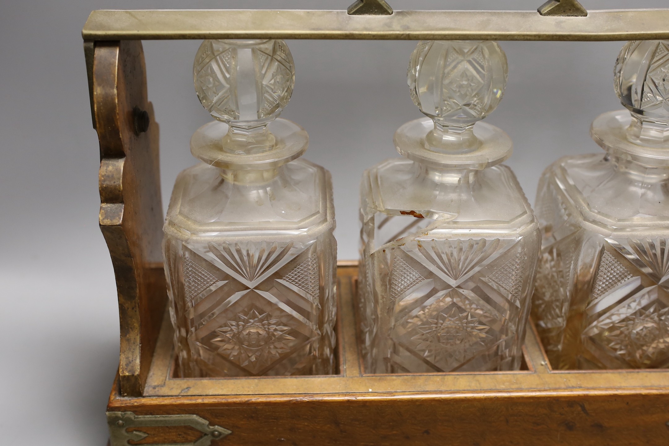 A Victorian Betjemann’s patent oak cased three bottle tantalus (a.f.), 42cms wide at base